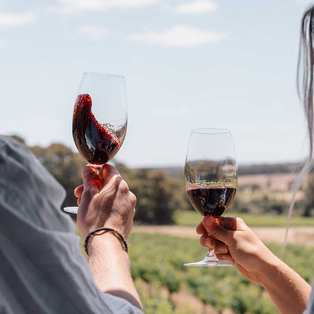 Two wine glasses held aloft on a Margaret River wine tour.